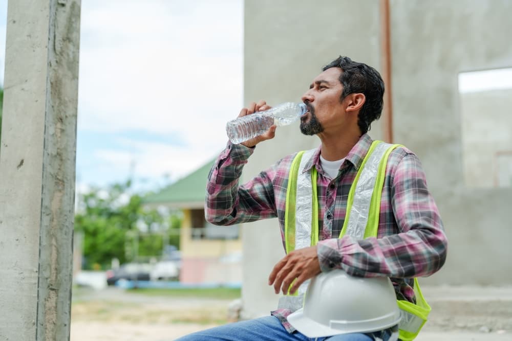 Man drinking water on construction site in India